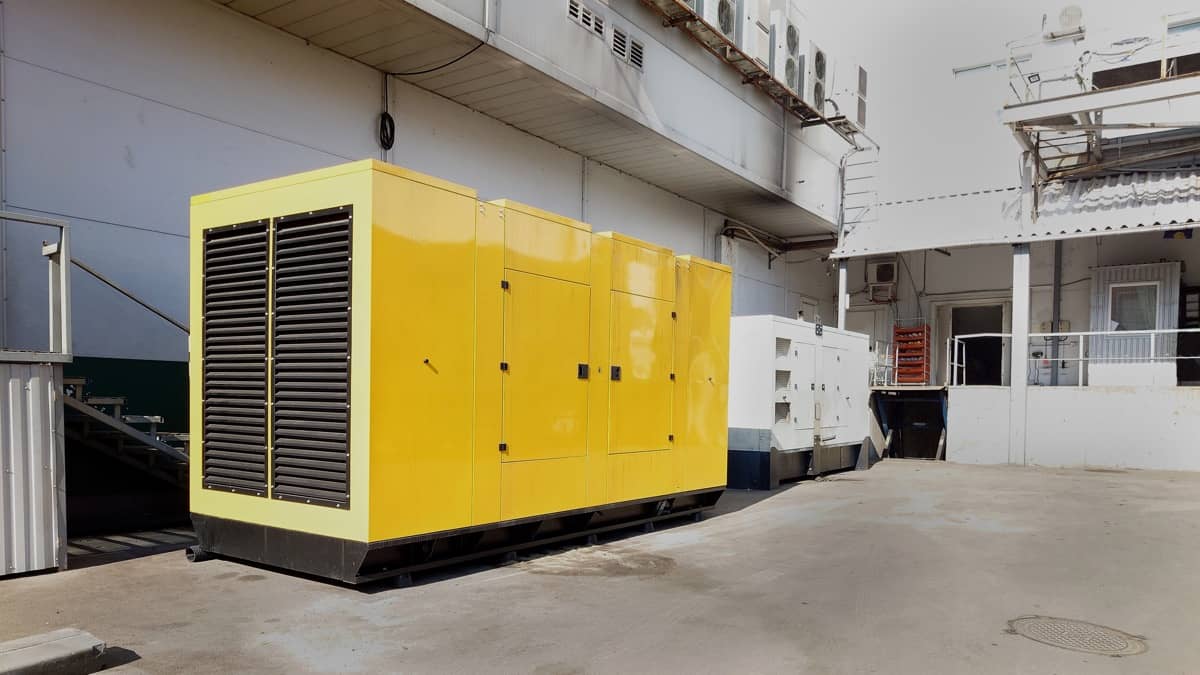 En stor gul generator på en industriell gårdsplan