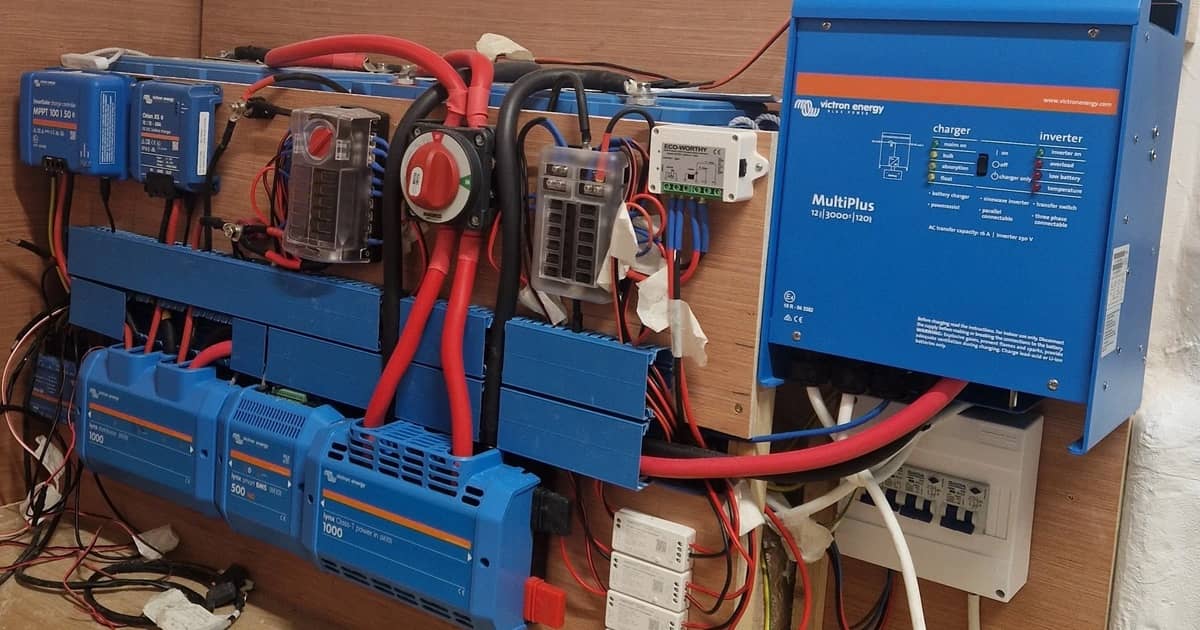 Victron växelriktare/laddare, solcellsladdare och samlingsskenor monterade på en husbilsvägg